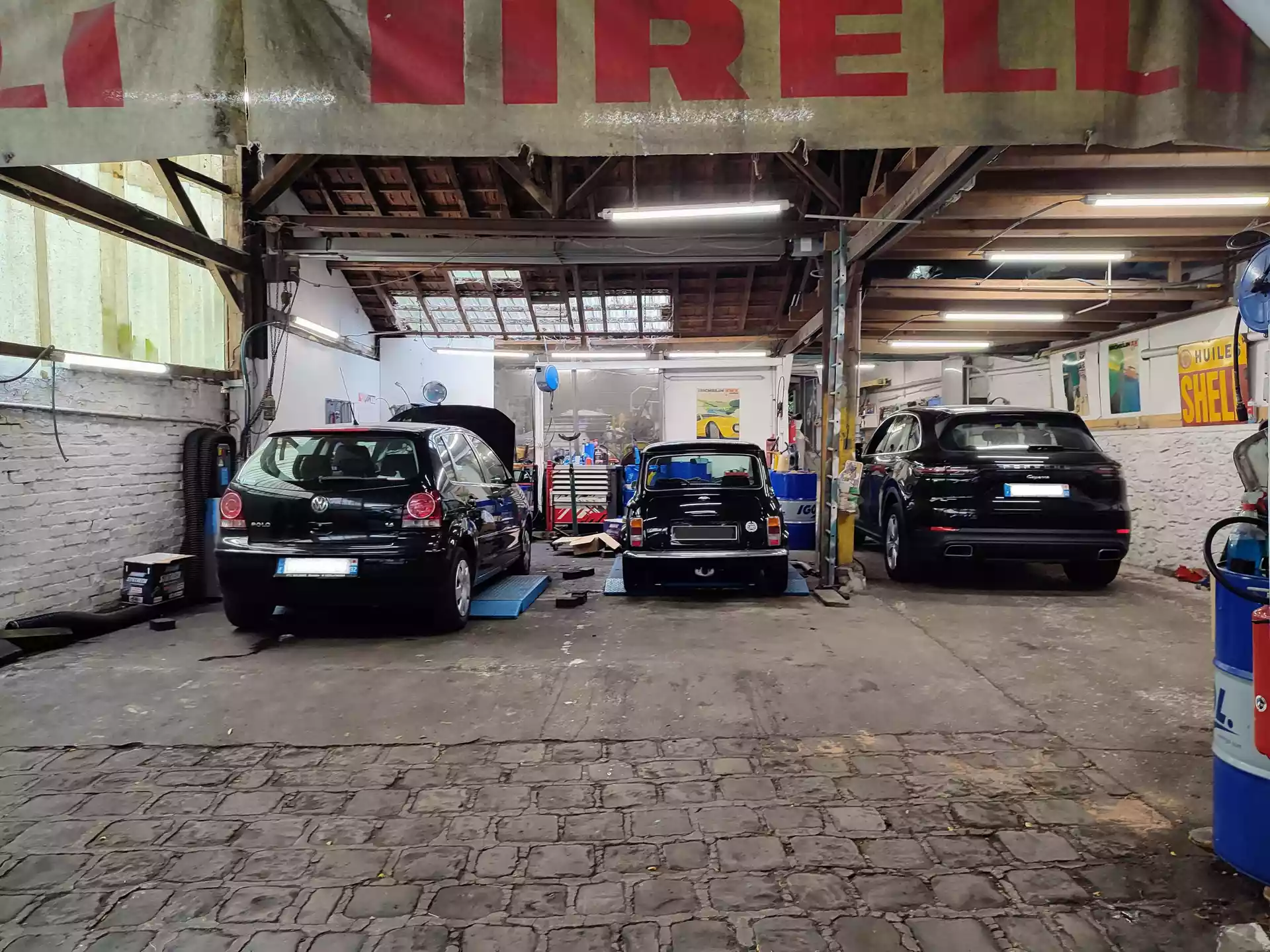 Volkswagen polo, mini et Porsche cayenne noir dans l'atelier Autorosati