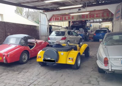 Lotus Seven Replica (Martin) jaune à l’entrée du garage Autorosati